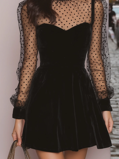 VESTIDO MINI DE TERCIOPELO NEGRO CON MANGAS TRANSPARENTES DE LUNARES Y CUELLO ALTO. ELEGANTE Y PERFECTO PARA FIESTAS. CONSÍGUELO HOY