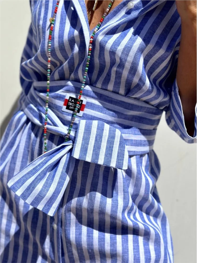 close up of blue striped midi dress showcasing the adjustable waist tie relaxed silhouette and lightweight summer styling ideal for vacations and casual chic outfits