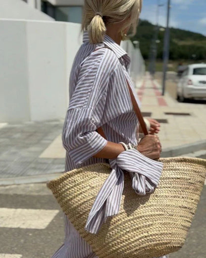 close up side view of khaki striped shirt midi dress with shirt collar button front and breathable relaxed fit ideal for vacations and everyday summer wear