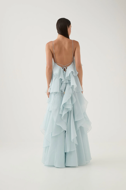 back view of light blue halter maxi dress with tiered ruffles and fluid movement elegant feminine style for weddings celebrations and summer occasions