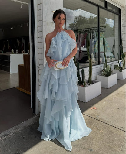 elegant light blue halter maxi dress featured in an indoor celebration showcasing layered ruffles flowing silhouette and sophisticated party ready styling for special events