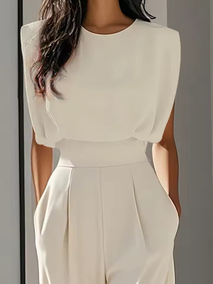 close up of white sleeveless jumpsuit featuring round neckline tailored bodice and waist defining belt refined modern womenswear for office looks events and elegant occasions
